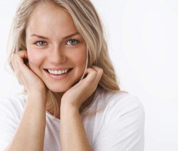 Headshot of attractive adult blond woman with tattoo leaning fac