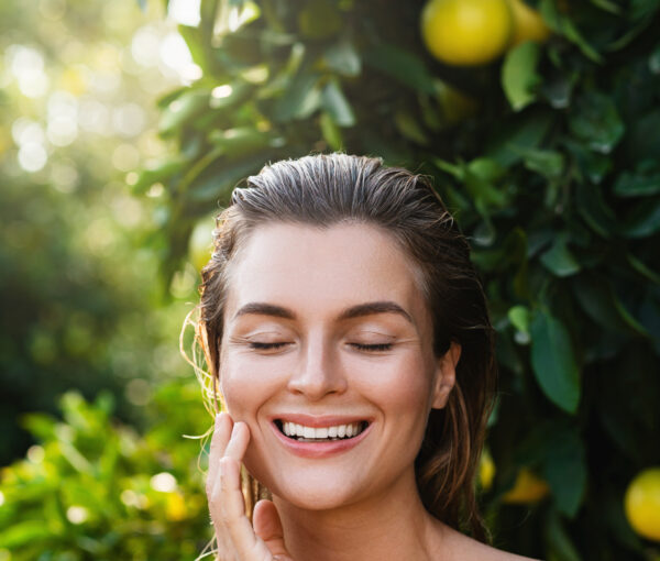 Portrait of beautiful woman with smooth skin against lemon trees